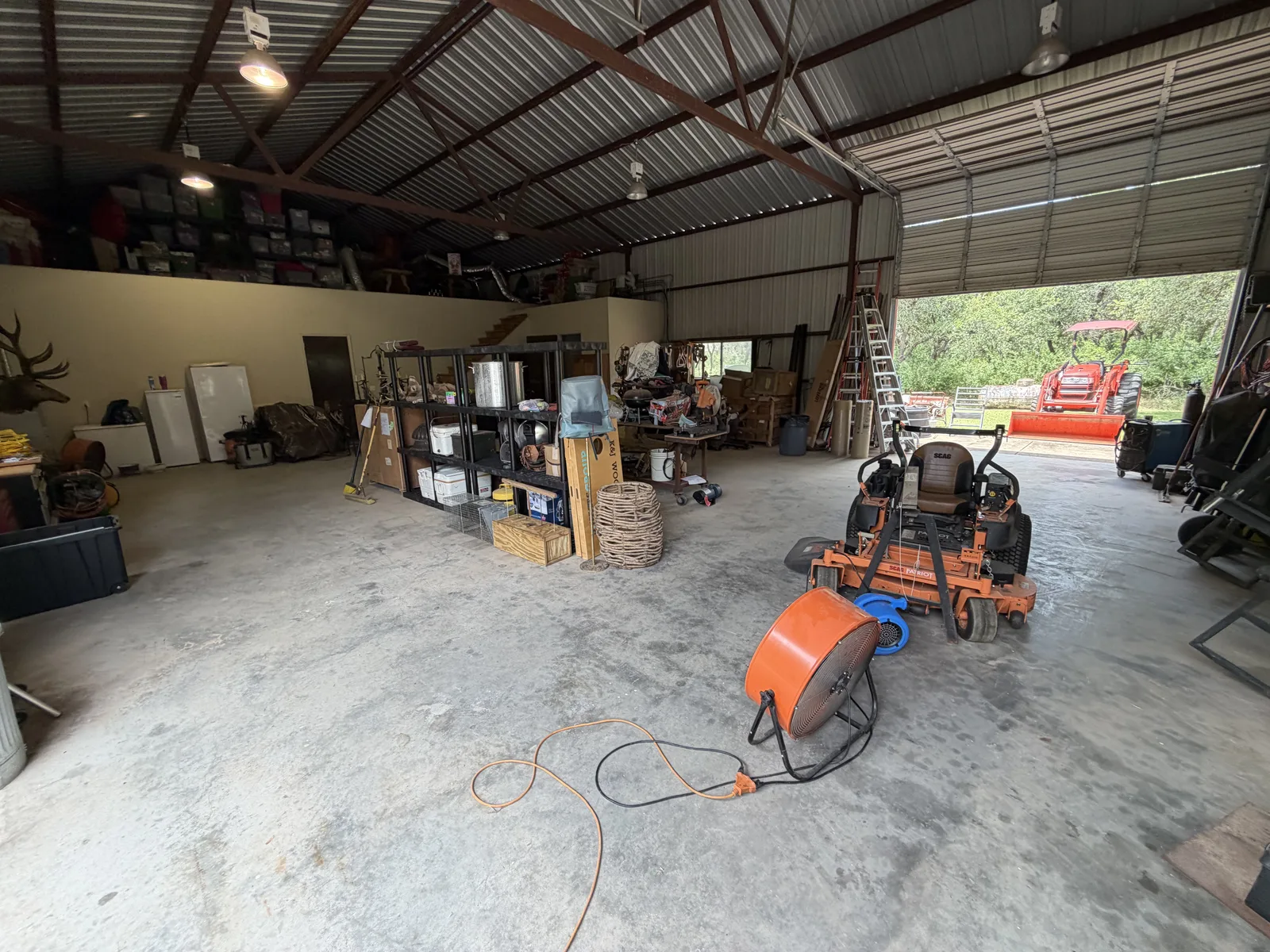 Barn workshop with swept clear floor and organized shelving after a one-day cleanout
