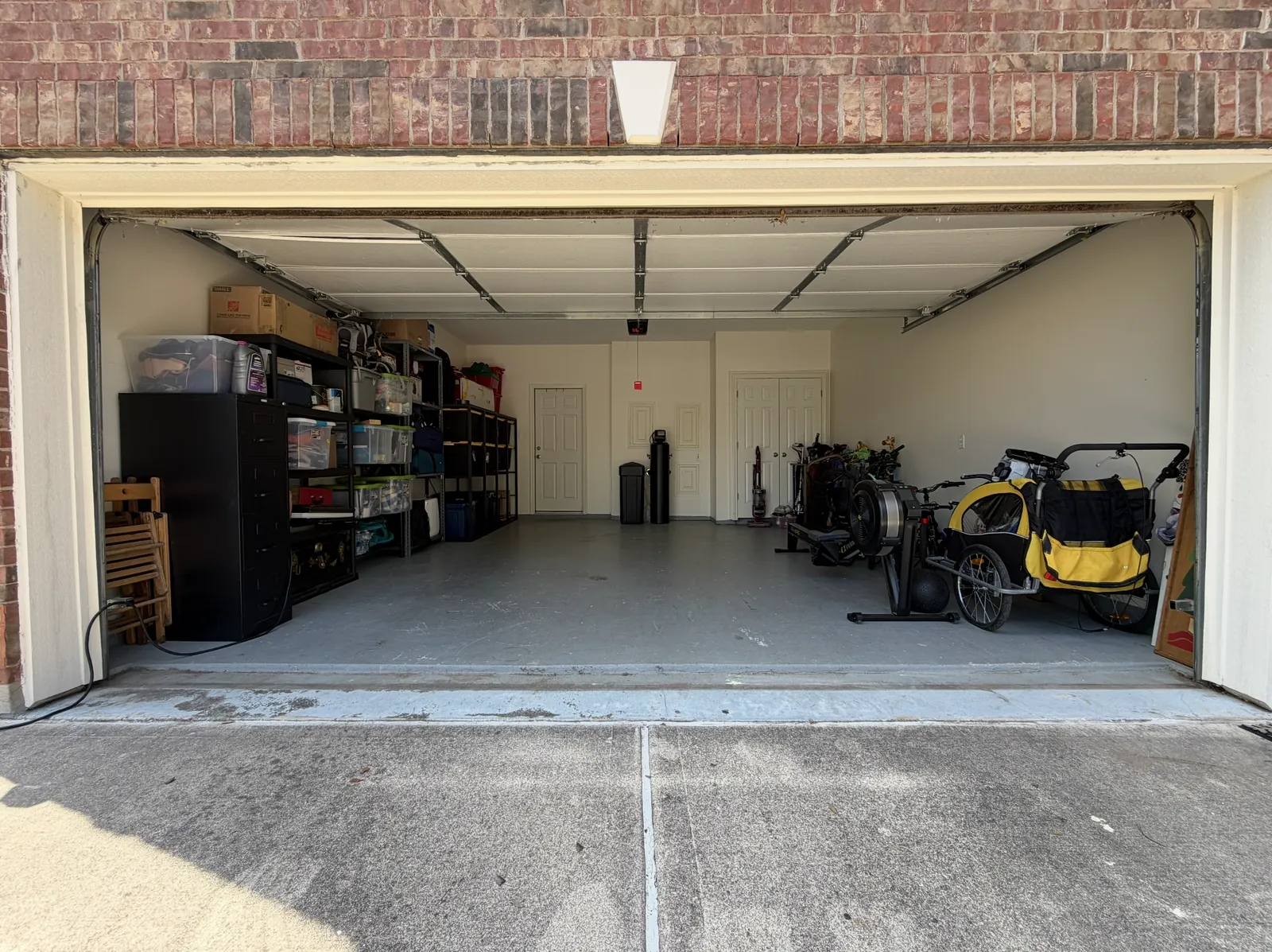 The same two-car garage with everything kept on shelves and the floor open after cleanout