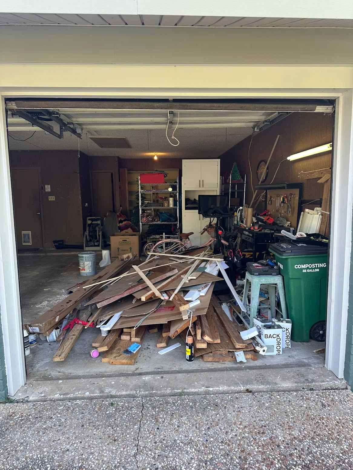 Garage filled with wood debris and clutter before cleanout