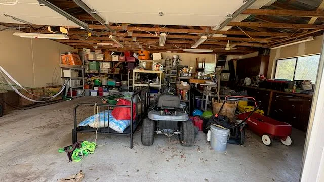 Overstuffed garage with boxes, toys, and equipment before cleanout